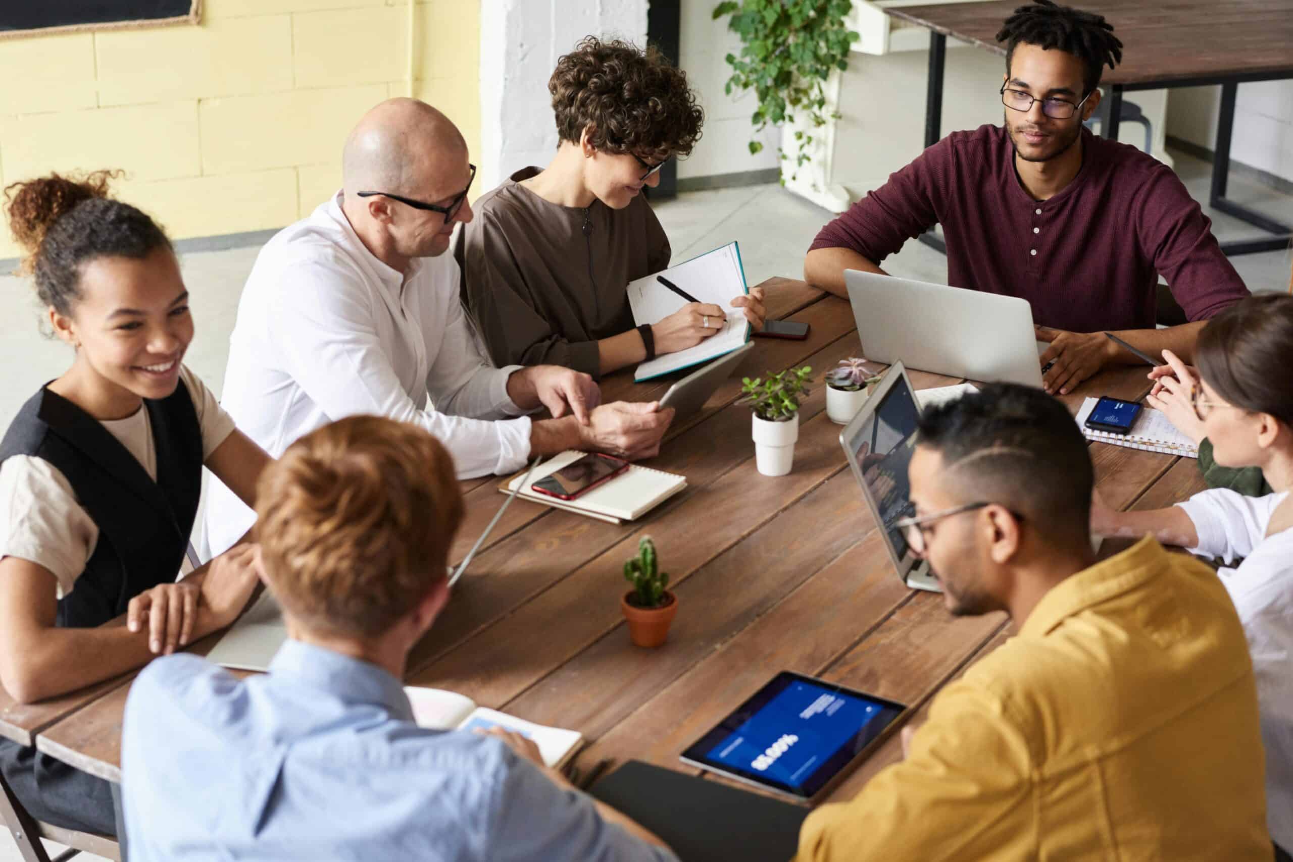 Photo of team working together around a wooden table