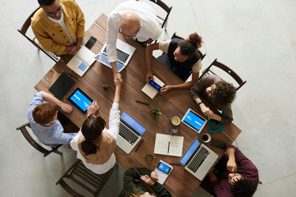 aerial view of team working together on AI strategy on laptops